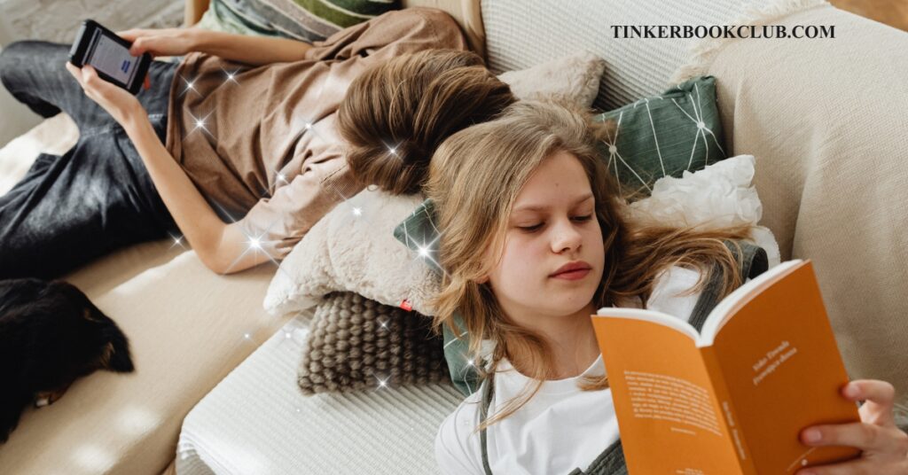 Two kids lying down reading on a couch, one from an e-book, one from a physical book. Encourage reluctant readers.