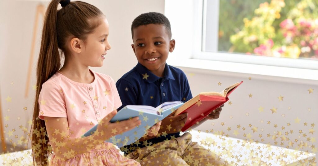 A young boy and girl smile at each other as they read books together. Classic books about friendship for kids.